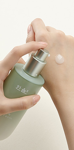 한율 어린쑥 수분진정 플루이드를 손등 위에 펌핑하는 예시