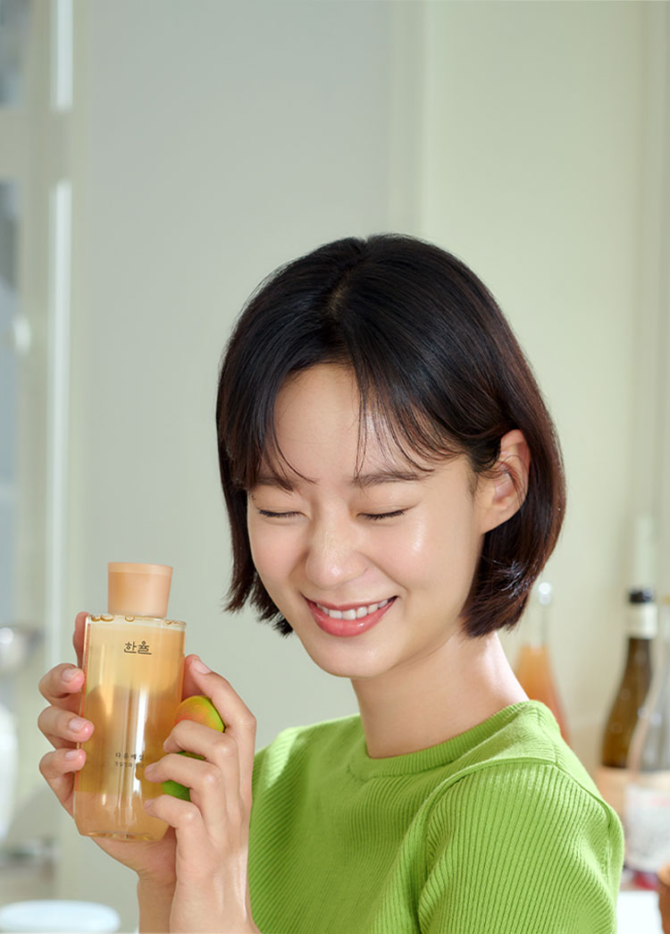 다홍 매실 각질정화 토너를 들고 있는 모델